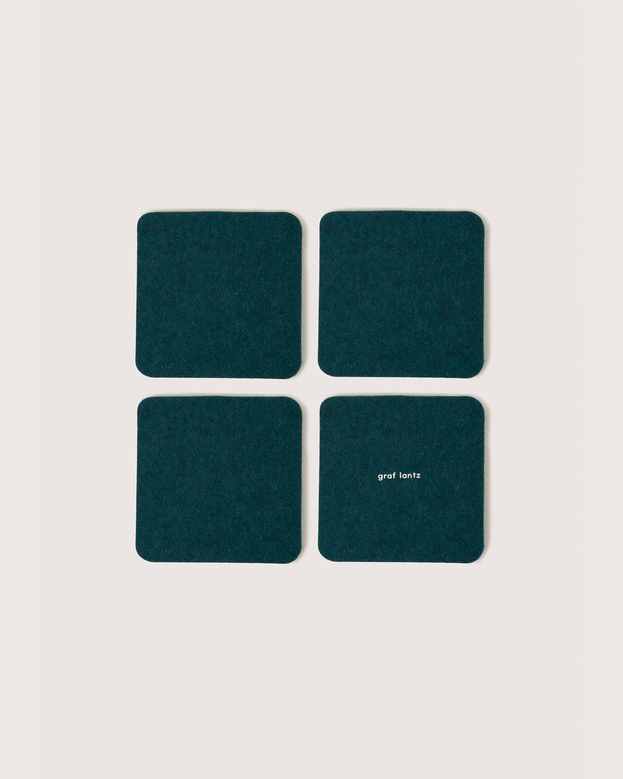 Four square coasters in color Kombu, white background