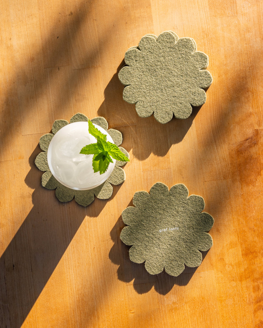 Hand-cut Merino Wool Felt Crest Coasters in sage color in a decorative setting