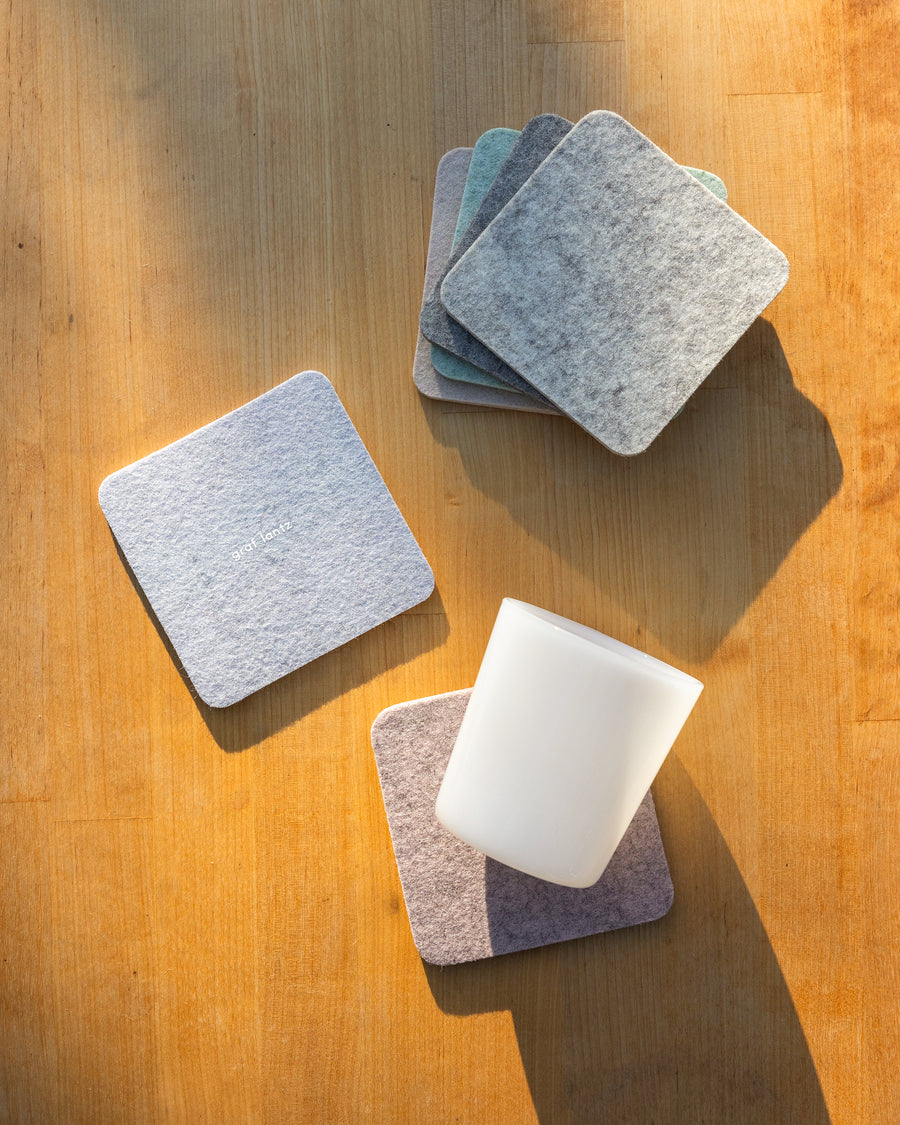 Four Merino wool felt coasters in square shapes and  two coasters below