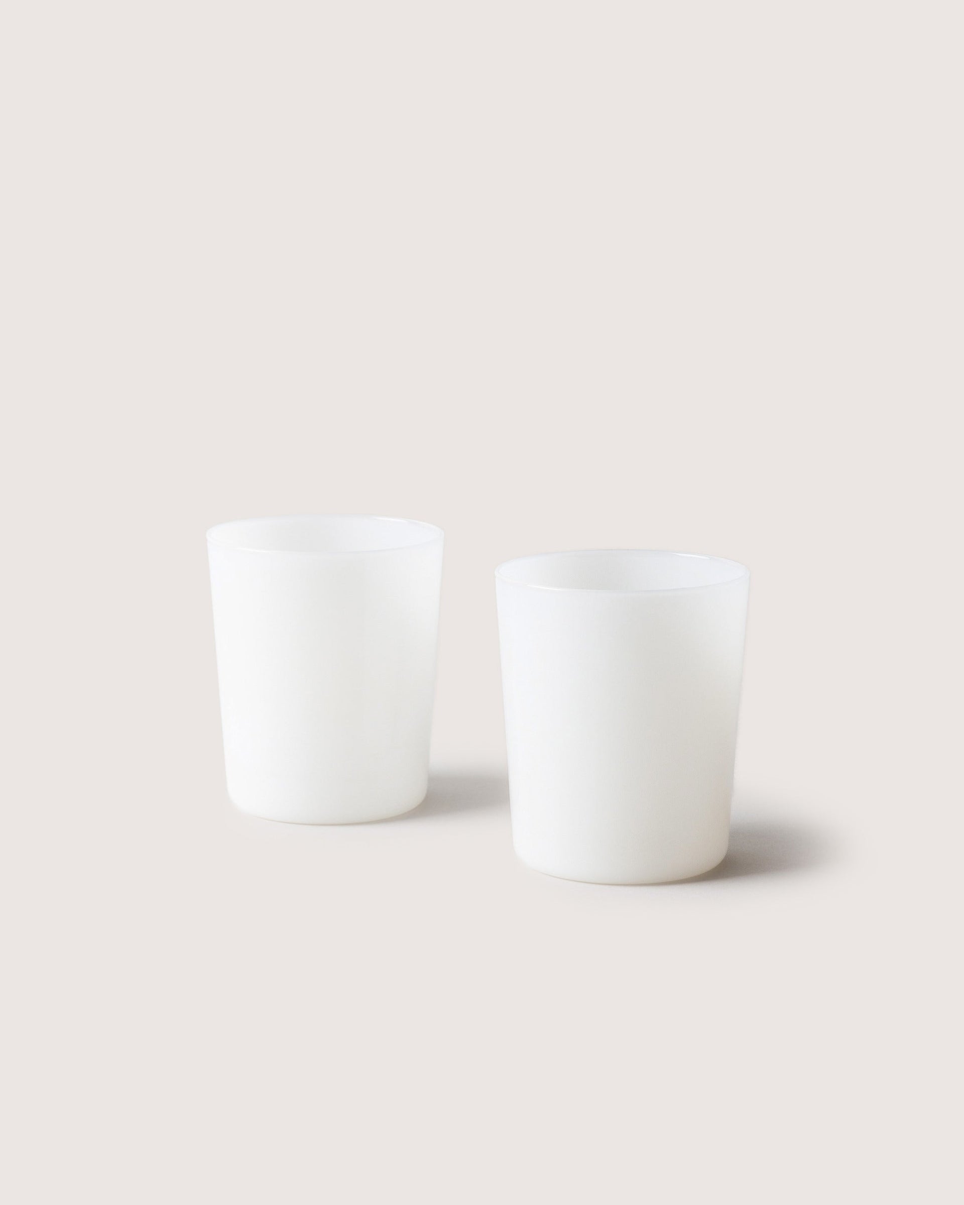 Two large Glas Tumbler in color foam, white background