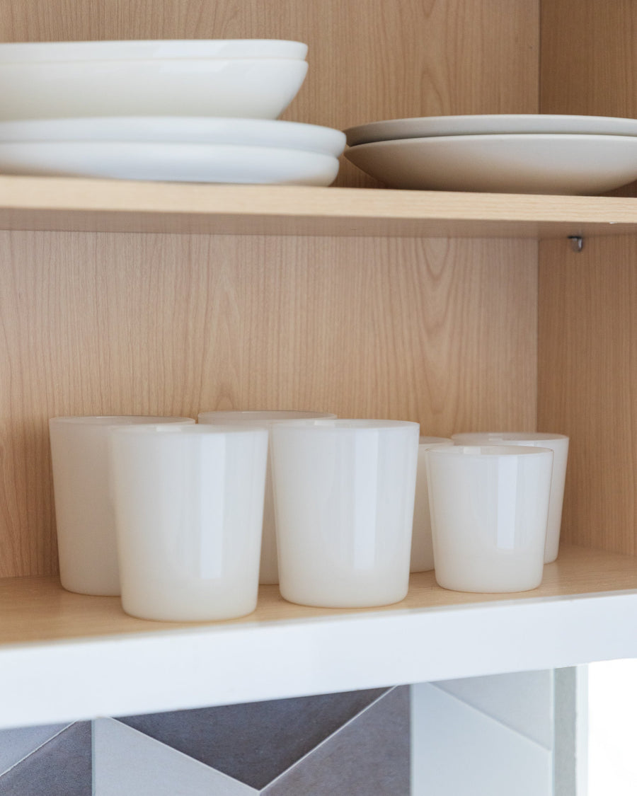 View inside a kitchen cabinet with different sized drinking glasses in color foam