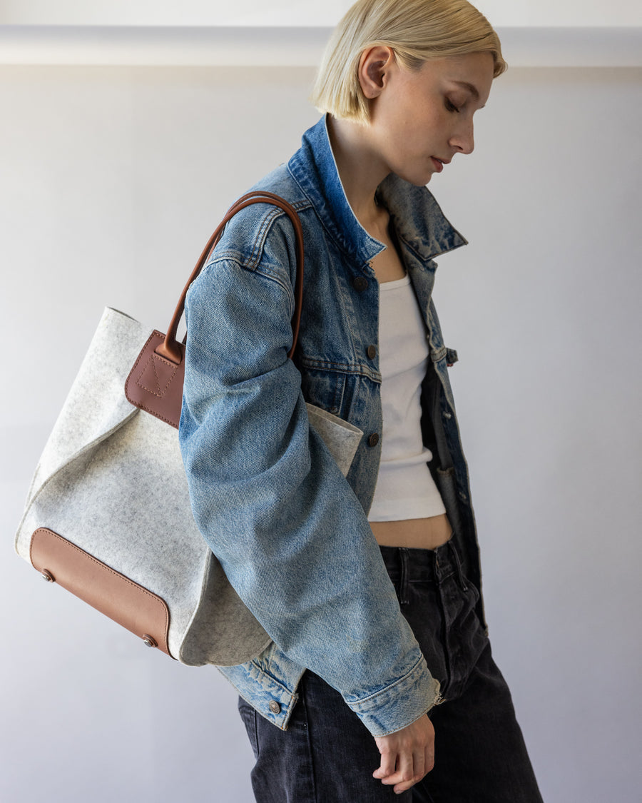 White Frankie Midi shoulder bag carried by woman over her shoulder, side view, white background