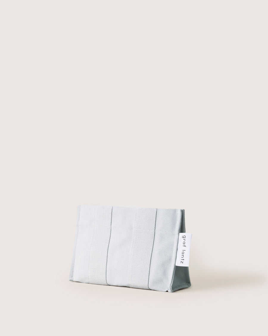 When the sun goes down it does double duty as a casual but elegant clutch: our Hako Pouch. Here in dove color.