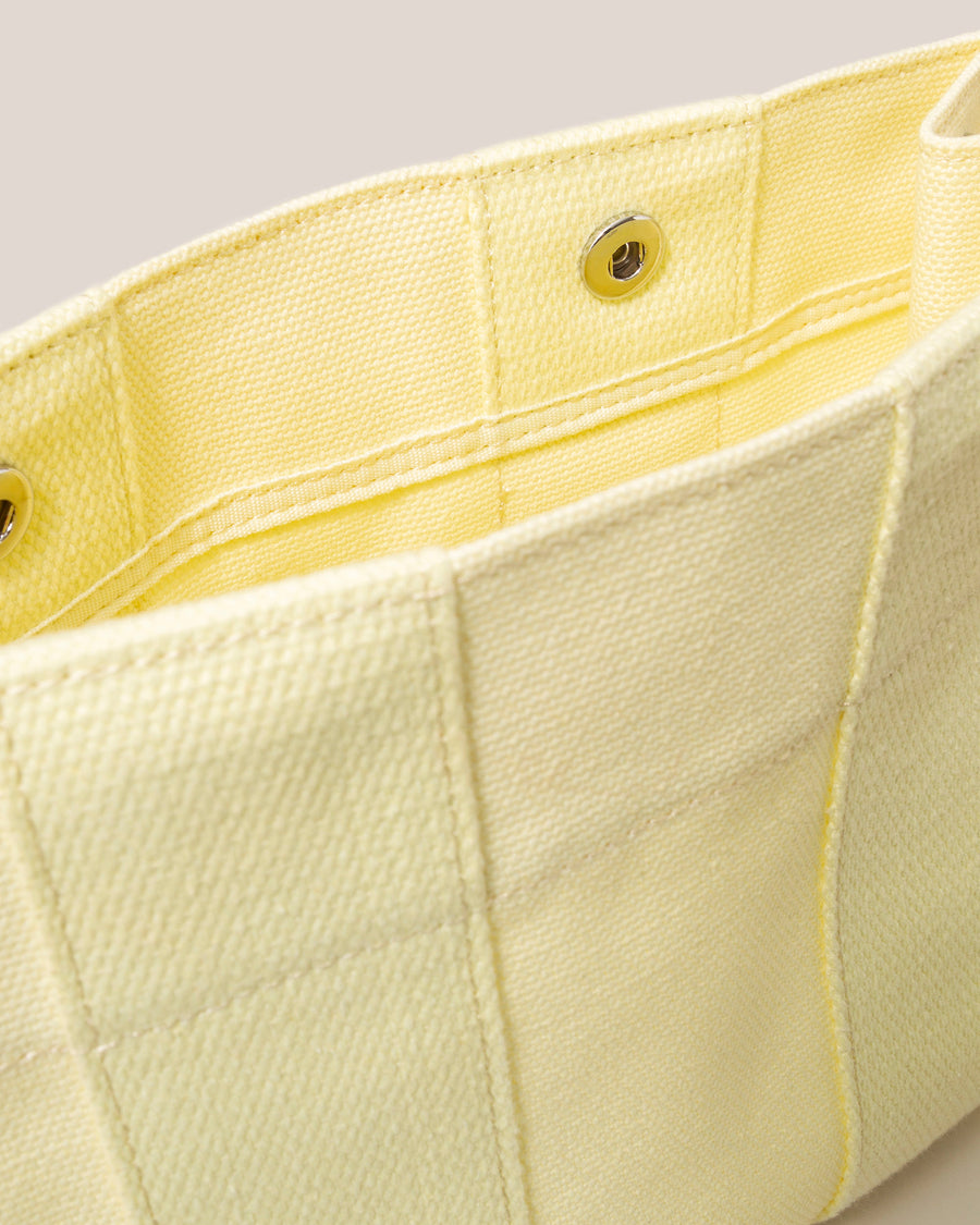 When the sun goes down it does double duty as a casual but elegant clutch: our Hako Pouch. Here in limoncello color.