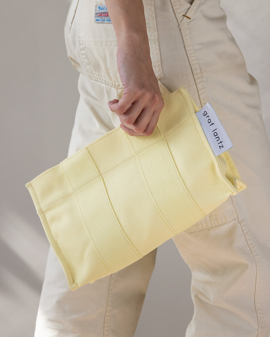 When the sun goes down it does double duty as a casual but elegant clutch: our Hako Pouch. Here in limoncello color.