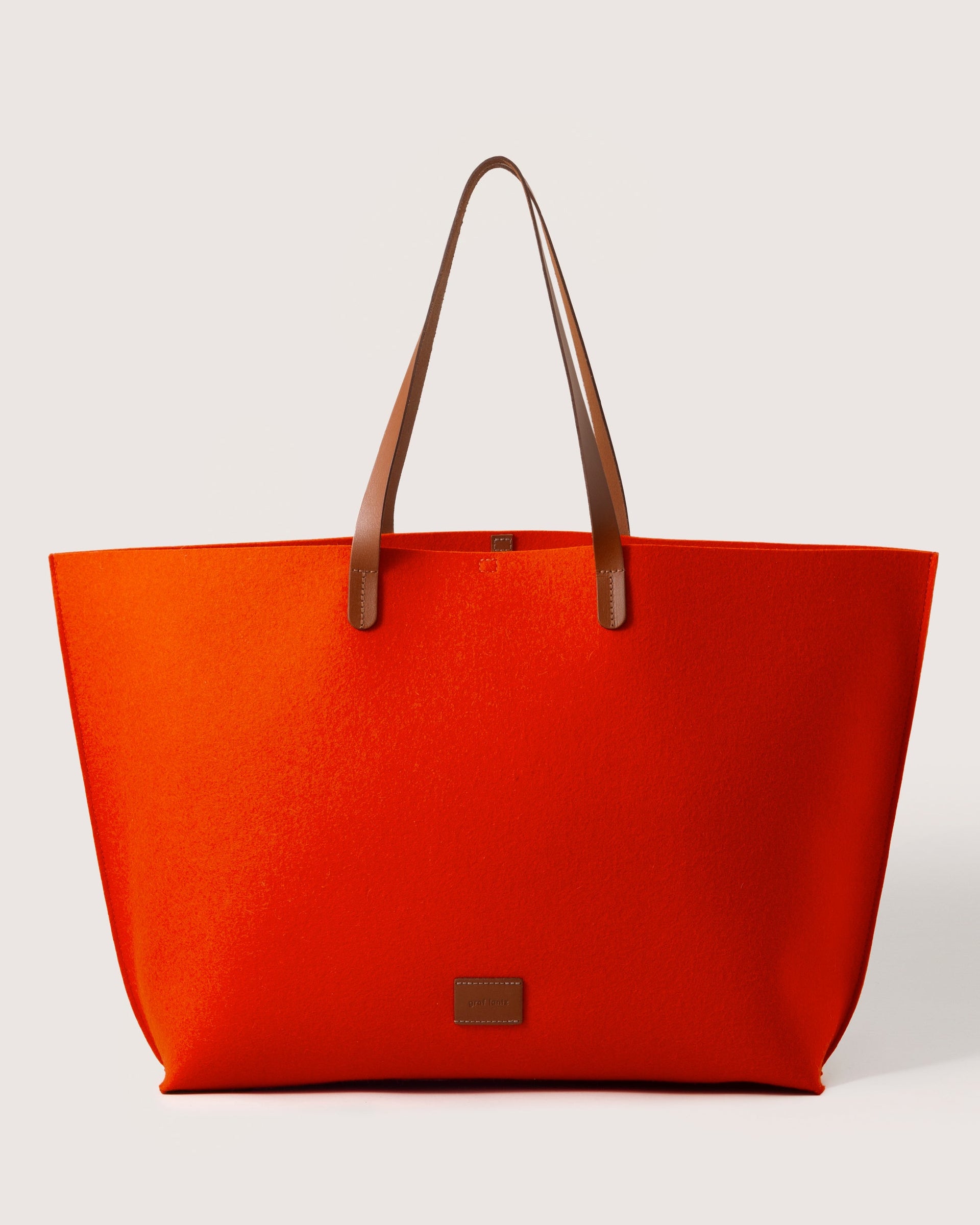 Orange Hana Merino Wool Boat Bag with brown leather handles and brand logo, front view, white background.