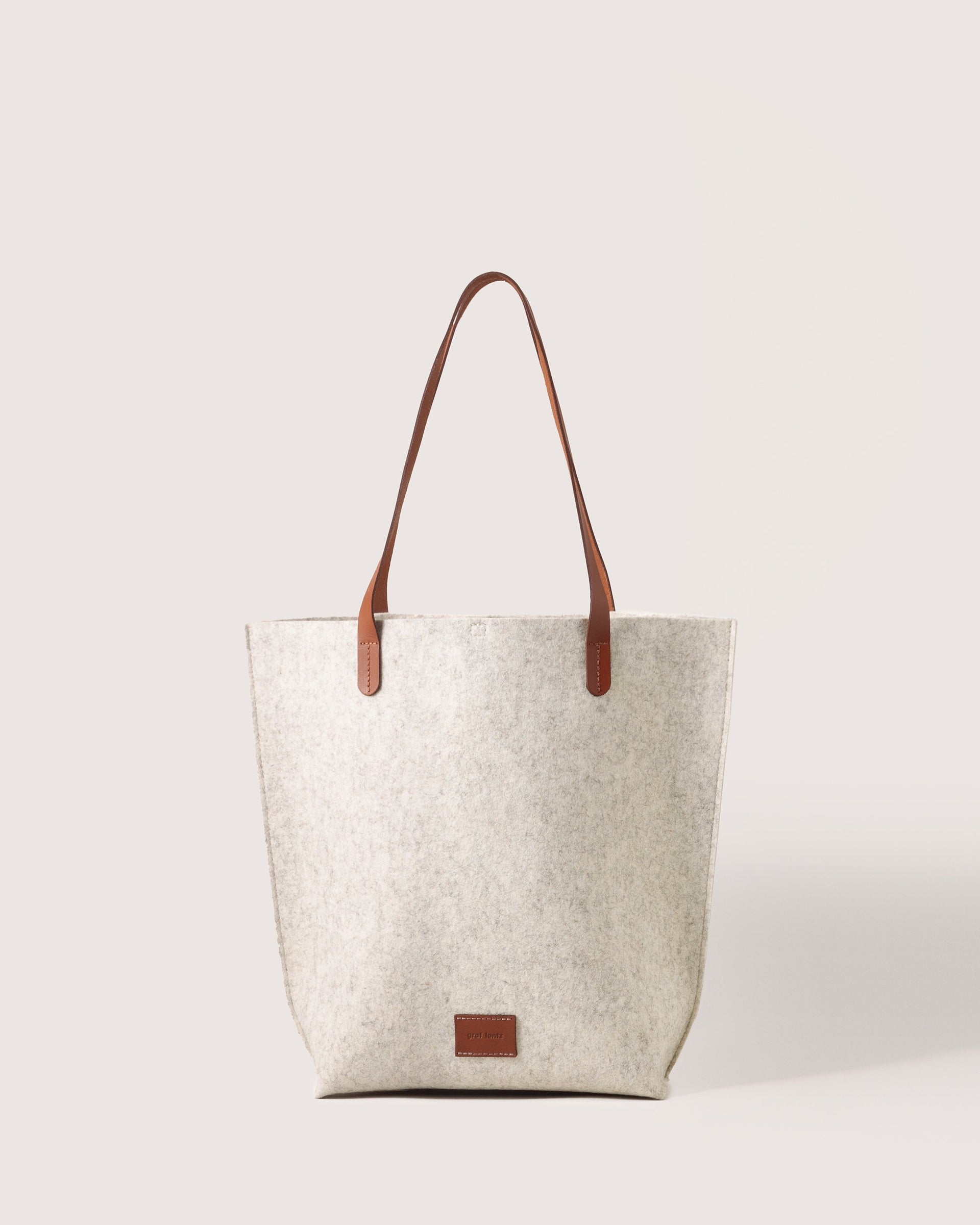 Heather white Hana Merino Wool Tote by Graf Lantz featuring brown leather handles and leather logo tag, front view, white background.