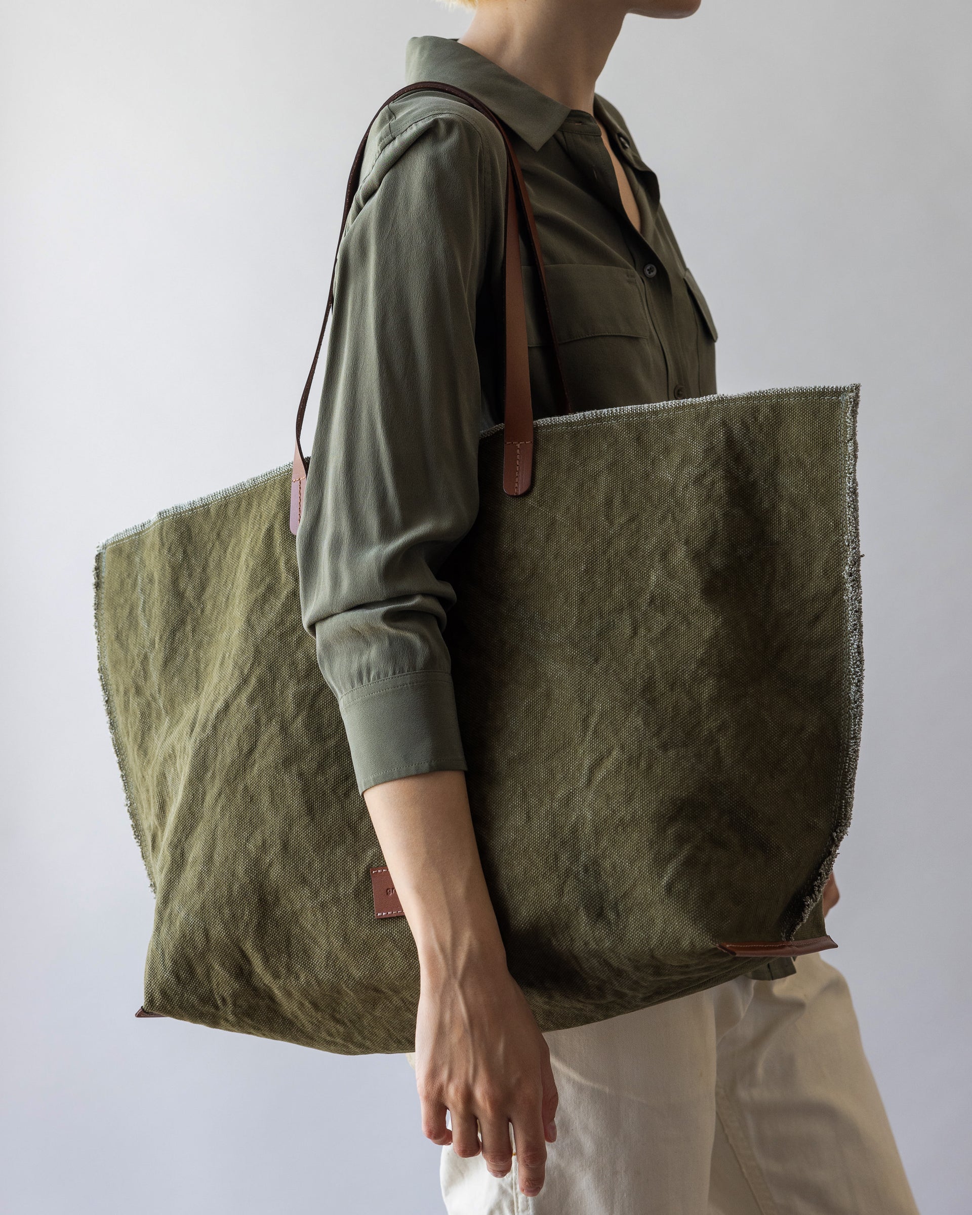 A blonde woman carrying an Olive Sienna Hana Canvas Boat Bag over her shoulder 