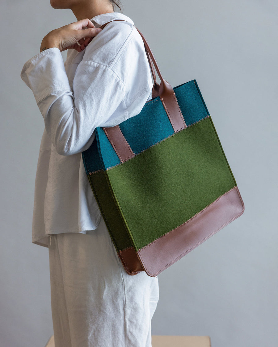 Woman with a Jaunt Merino Wool Tote in Moss and Kombu over shoulder, side view