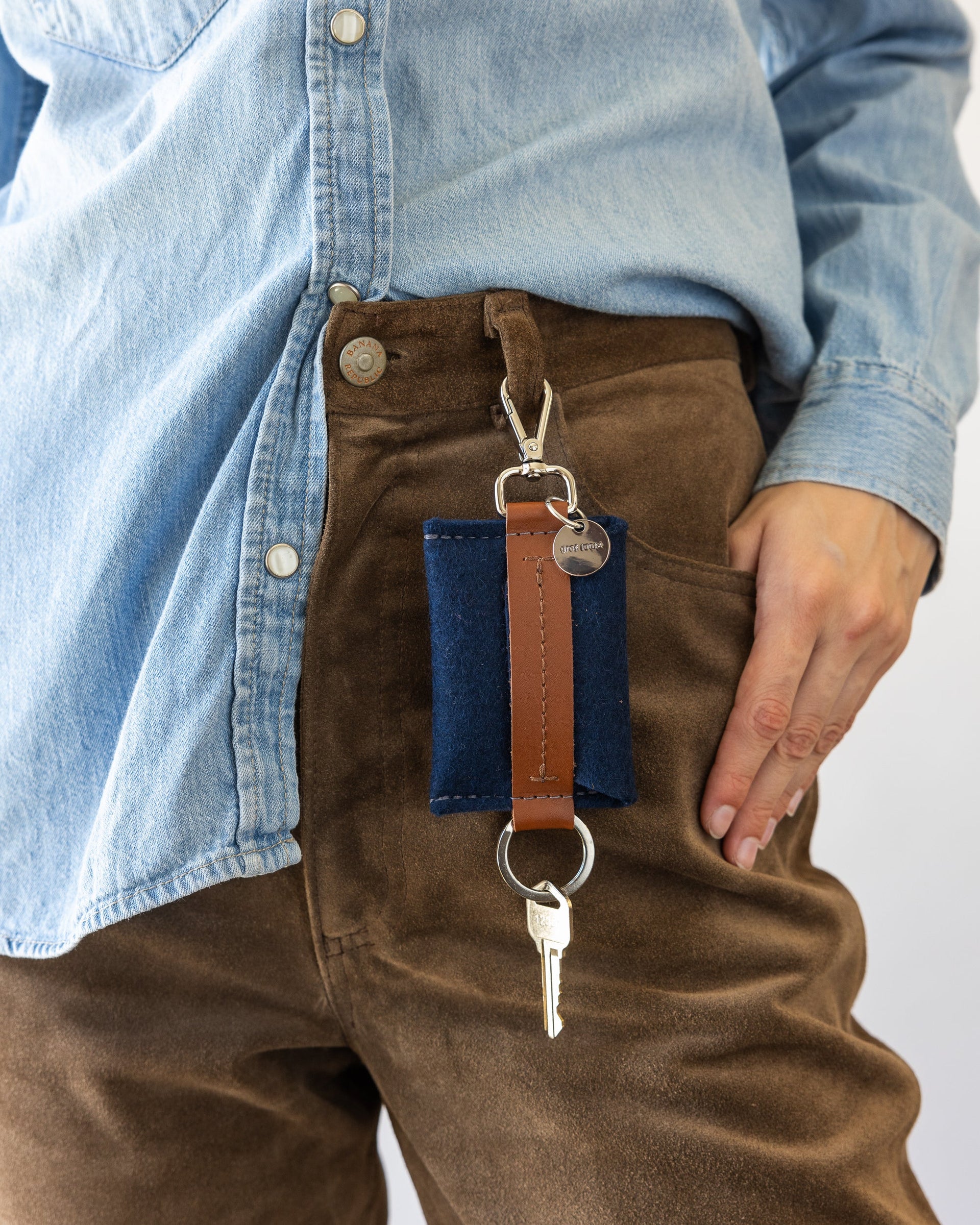 Blue Merino Wool Card Key Fob on woman's belt loop of brown pants, front view.