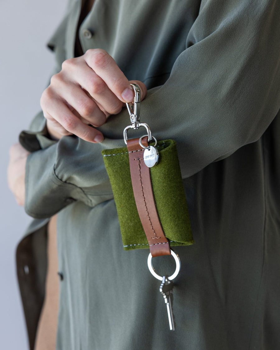 Woman holds green Merino Wool Card Key Fob with brown leather application by Graf Lantz in one hand