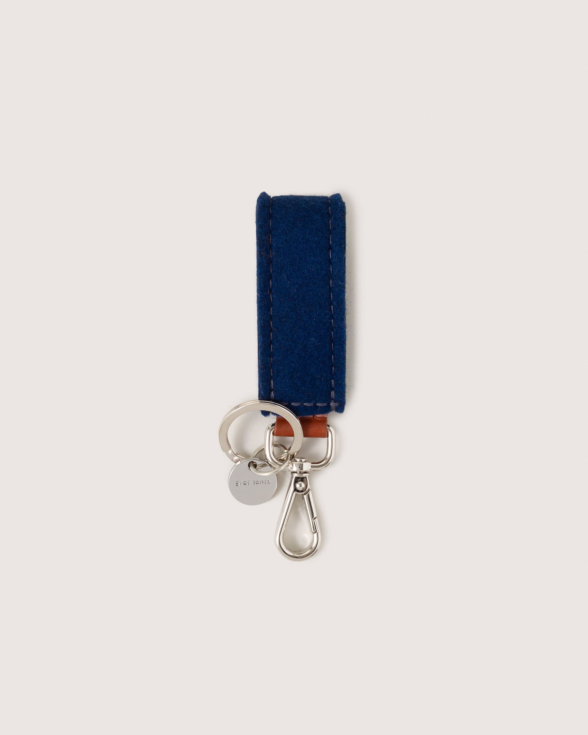 Marine Merino Wool Loop Key Fob with silver colored Lobster Clasp, Flat Wide Keyring, and Logo Tog Tag, white background.