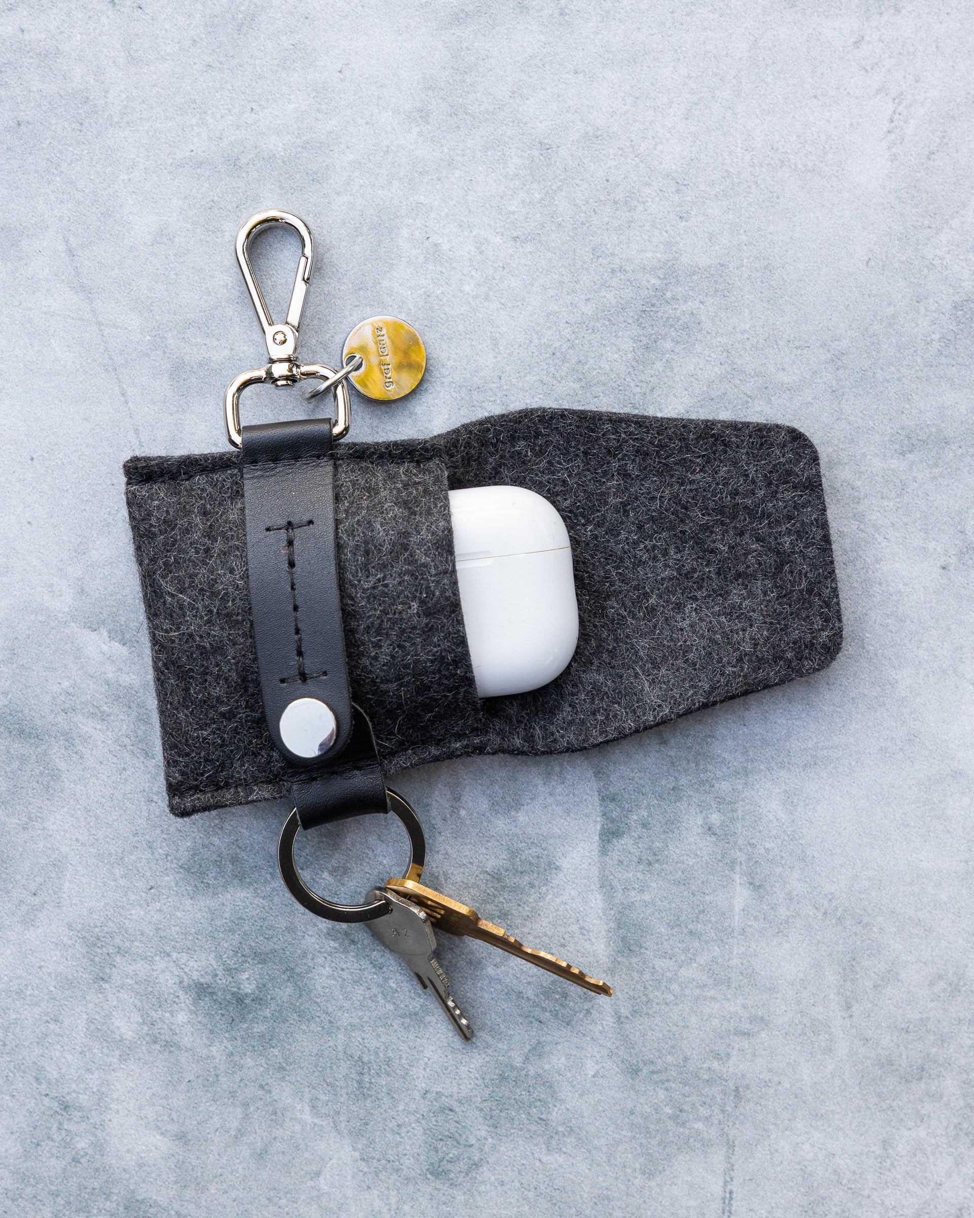 Charcoal Merino Wool Pod Key Fob by Graf Lantz with open flap on marble tabletop