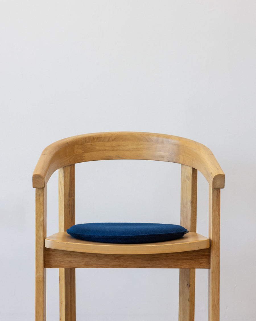 Blue Zabuton Merino Wool Round Seat Pad on a wooden chair, white background