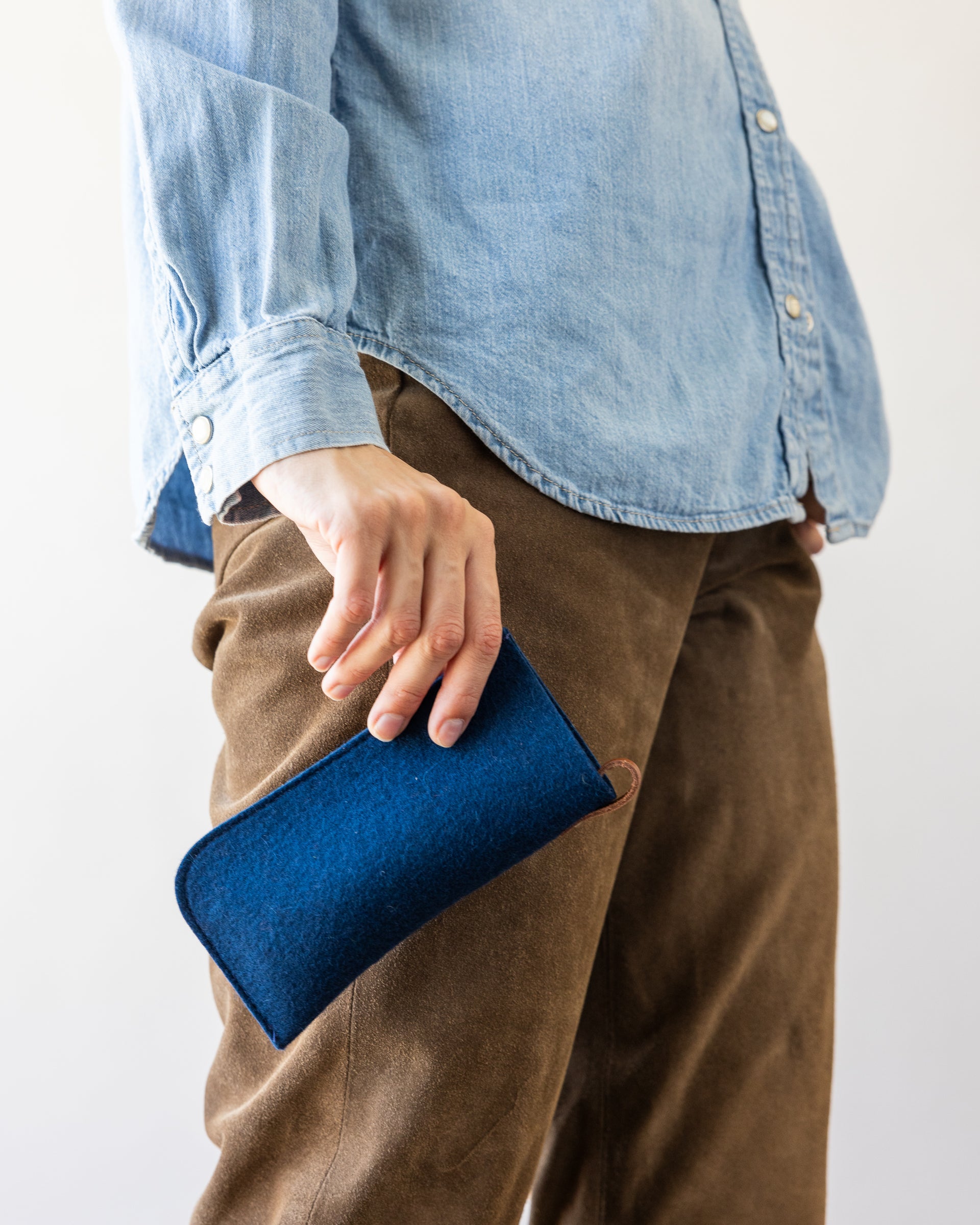 Woman holding a Merino marine Wool Felt Eyeglass Sleeve in her hand, side view