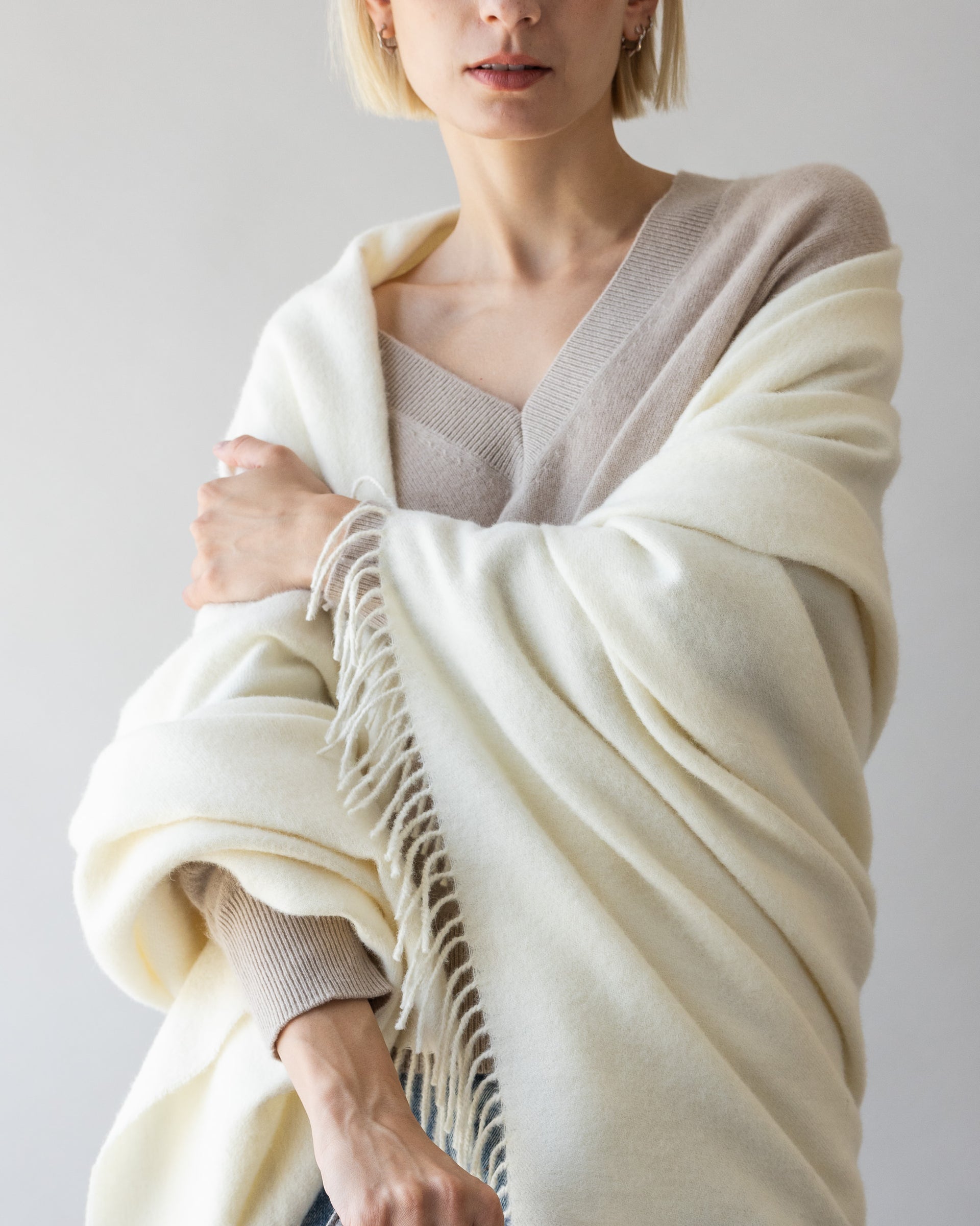 Blonde woman with a white alpaca throw by Graf Lantz over her shoulders 