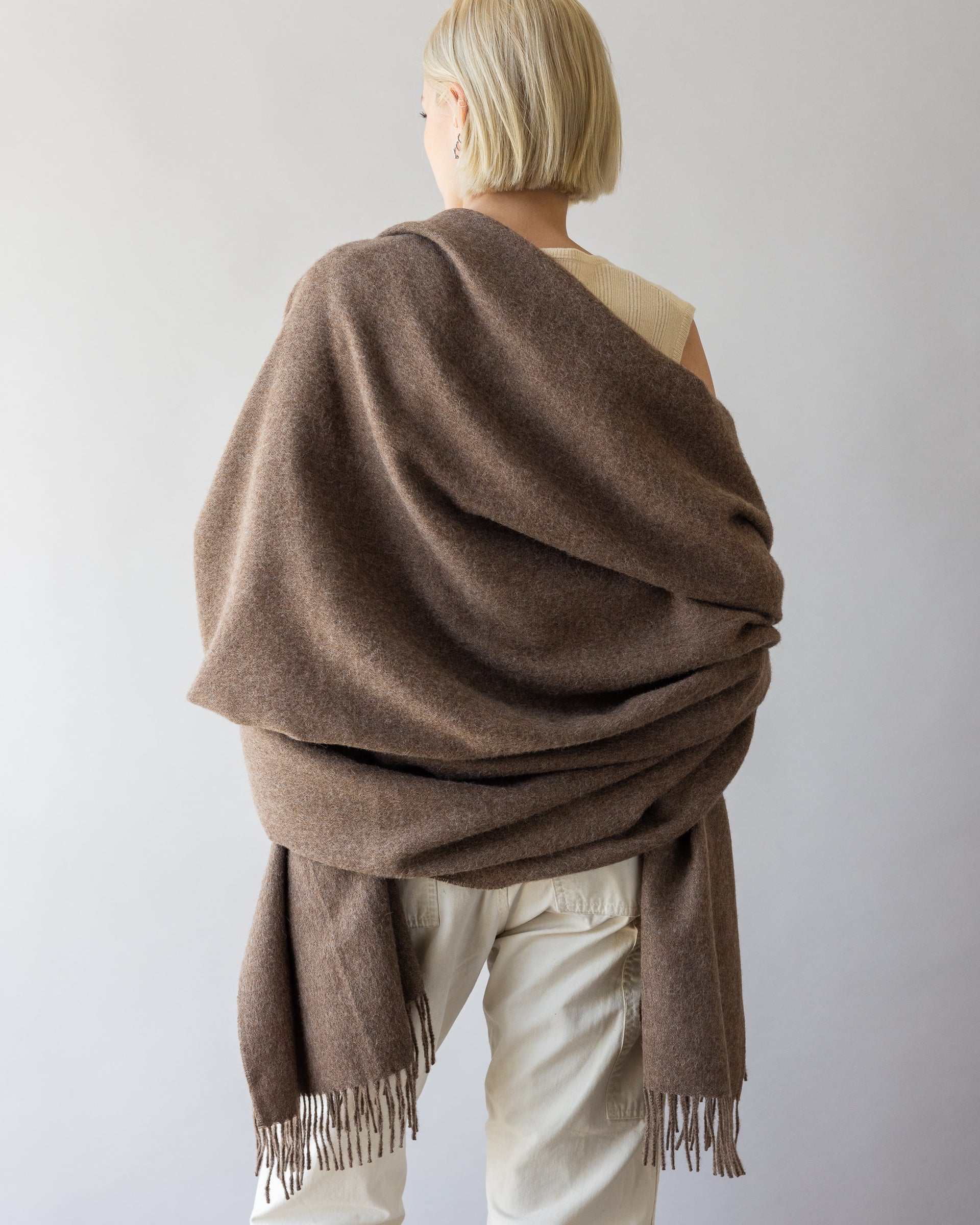 View of a womans back with brown alpaca throw over her shoulders