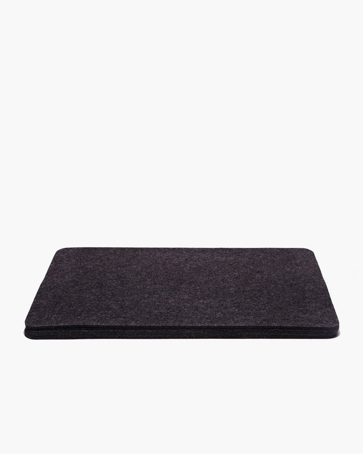 A dark gray rectangular felt object, likely the Merino Wool Placemat by graf lantz, rests against a plain white background. It features a soft texture with slightly rounded edges, exuding designer-inspired elegance.